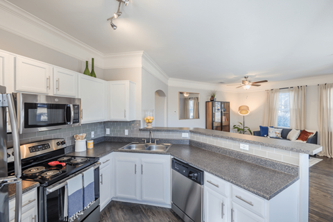 an open kitchen with granite counter tops and white cabinets